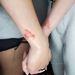 Парная татуировка: два огня на запястьях, выполненные в тонкой графике красными и оранжевыми оттенками