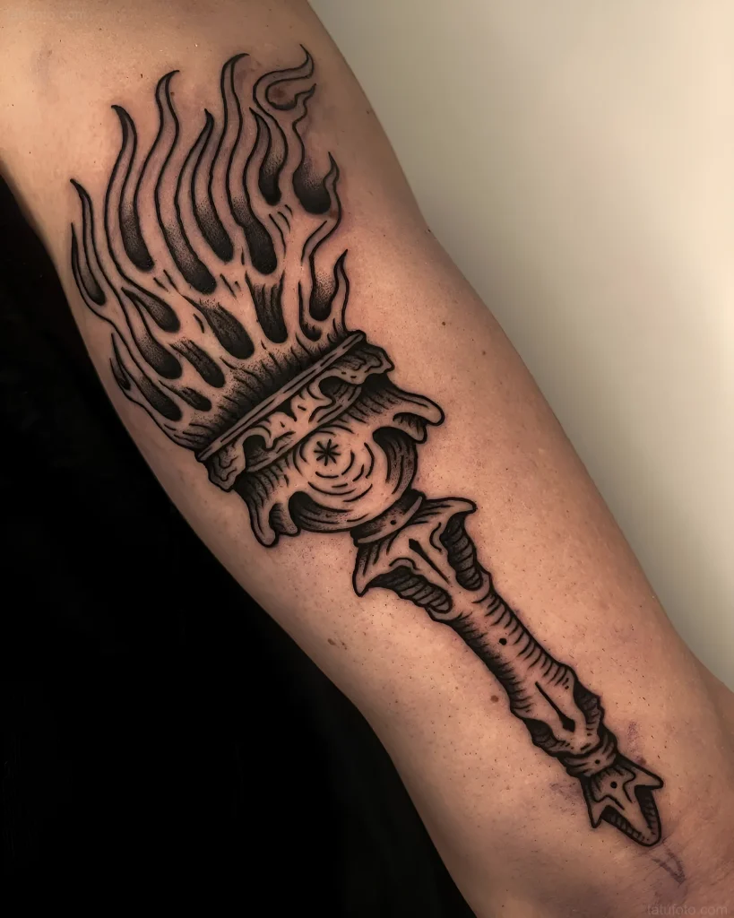 Tatuaje estilo old school con una antorcha encendida que simboliza el fuego eterno.