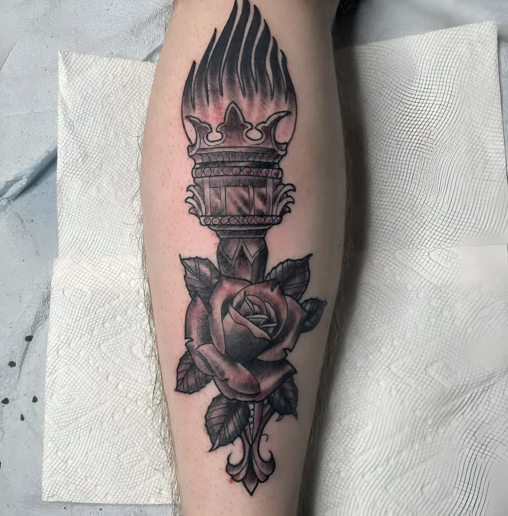 带有玫瑰的永恒之火腿部纹身,采用黑灰色调