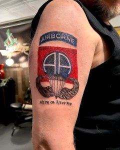 Татуировка с символикой ВДВ: нашивка AIRBORNE, парашют и эмблема подразделения на руке