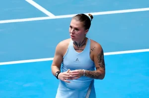 Теннисистка Олеся Олейникова стоит на корте Australian Open, демонстрируя татуировки на лице и теле.