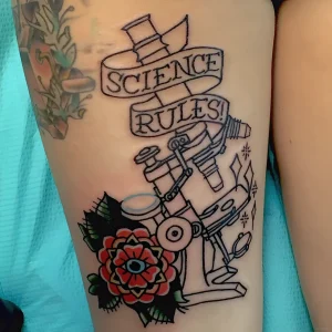 Татуировка микроскоп с лентой 'Science Rules!' и стилизованным цветком