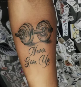 Реалистичная татуировка гантели с надписью 'Never Give Up' на предплечье