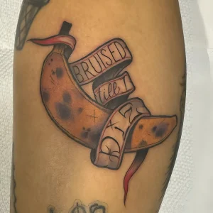 Реалистичная татуировка банана с надписью "BRUISED till I die"