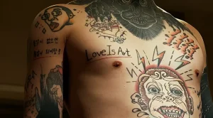 Татуировка "Love Is Art" на груди с изображением обезьяны, молний и корейской надписи на руке
