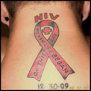 Татуировка красной ленты на шее с надписью 'My New Life Began On HIV' и датой