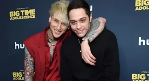 Пит Дэвидсон и Machine Gun Kelly обнимаются на фоне баннера "Big Time Adolescence"