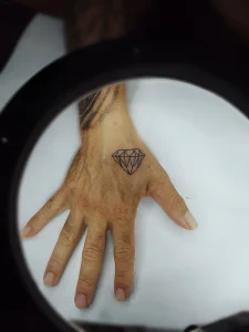 Татуировка алмаз на тыльной стороне кисти руки, выполненная в минималистичном стиле
