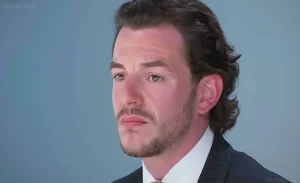 Крупный план лица Кирана Маккартни, участника шоу «The Apprentice», с задумчивым выражением.