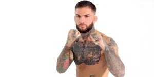 UFC боец Коди Гарбрандт в стойке, демонстрируя свои многочисленные татуировки на груди, шее и руках.