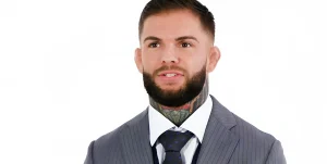 UFC боец Коди Гарбрандт в деловом костюме, показывающий свои татуировки на шее