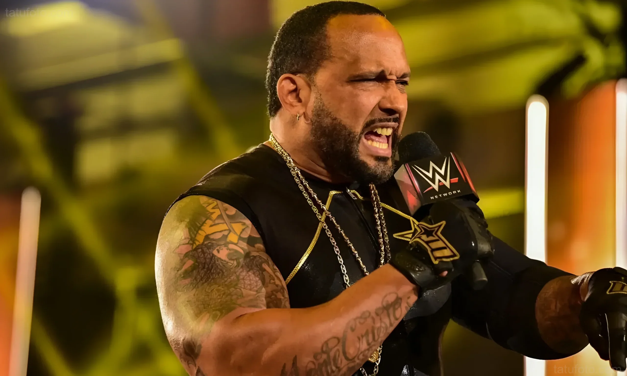 MVP, бывшая звезда WWE, говорит в микрофон WWE, видна его татуированная рука.