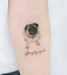 Реалистичная татуировка мопса с надписью "Always by my side" на предплечье