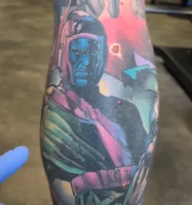 Крупный план татуировки персонажа Marvel Канга Завоевателя на руке Тома Рэдфорда, демонстрирующий яркие цвета и детализацию.