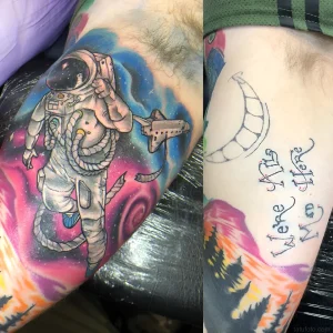 Яркая татуировка космонавта на фоне космического пространства, рядом с миниатюрным шаттлом