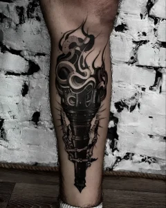 Татуировка факела в готическом стиле, который держат костяные руки, с языками пламени, выполненная в технике графика