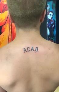 Татуировка ACAB на шее сзади
