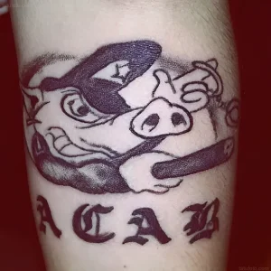 Черно-белое тату свиньи в шляпе с сигарой и надписью ACAB