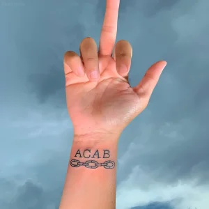 Татуировка ACAB с изображением разорванной цепи на запястье
