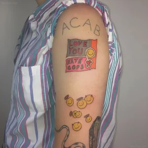 Татуировка ACAB на плече с надписью 'Love You Hate Cops' и смайликами