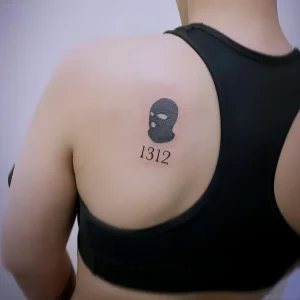 Татуировка маски балаклавы с числом 1312 на плече
