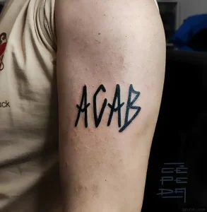 Татуировка ACAB, выполненная в графическом стиле, на предплечье