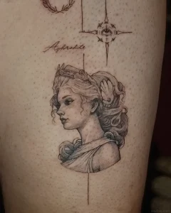 Татуировка Афродиты в профиль, выполненная в стиле гравюры, с надписью 'Aphrodite' и мистическим глазом