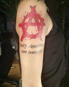 Татуировка символа анархии с красными брызгами и цитатой "Only Anarchists are beautiful"