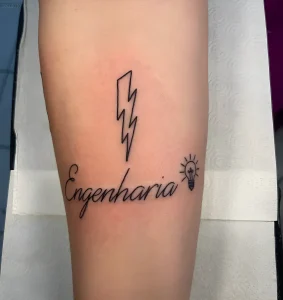 Татуировка с надписью Engenharia, молнией и лампочкой на ноге