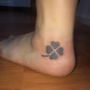 Черно-белая татуировка четырехлистного клевера на внешней стороне стопы в технике дотворк