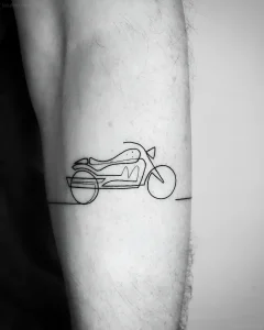 Черно-белая фотография свежей татуировки мотоцикла в стиле line art на предплечье мужчины, выполненная тонкими линиями