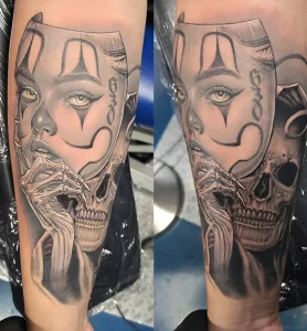 Detailed black and white tattoo on the forearm, depicting a girl's face in a Day of the Dead mask with a bone hand and a skull