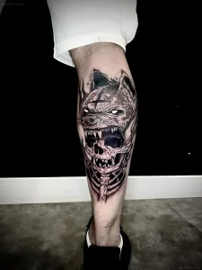 Модель с уникальной черно-белой татуировкой на икре, изображающей скелетную голову волка, демонстрирующая стиль для портфолио
