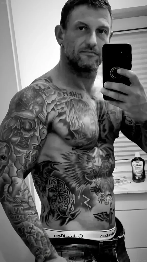 Mann mit umfangreichen realistischen Tätowierungen am Körper, der ein Beispiel für ein Tattoo-Model zeigt.