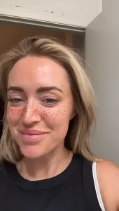 Крупный план портрета Блисс Лавэлл с татуированными веснушками на лице, улыбается.