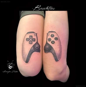 Две руки с парными татуировками в виде половинок геймпада PlayStation, черно-серый реализм, игровая тематика