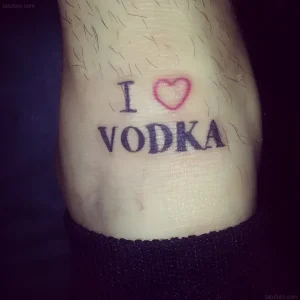 Фотография татуировки на лодыжке с надписью I Love Vodka и красным сердечком