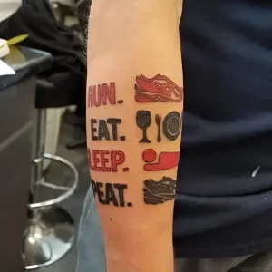 Яркая татуировка на предплечье с надписью Run Eat Sleep Repeat и иконками кроссовок, еды, вина и сна