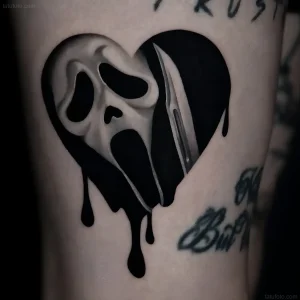 Черно-белая татуировка в форме сердца, внутри которой изображена маска Ghostface из фильма «Крик» с ножом, стекающая чернилами — символ ужаса и эмоциональной боли