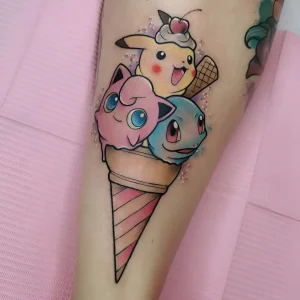 Татуировка на ноге с изображением трех покемонов: Pikachu, Jigglypuff и Squirtle, расположенных в конусе мороженого