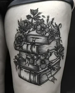 Черно-белая татуировка на бедре: стопка старых книг, из которых растут цветы, выполненная в стиле графика с акцентом на текстуры и штриховку