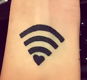 Черно-белая татуировка в стиле минимализм на запястье: символ Wi-Fi с сердцем вместо точки, выполненный в технике blackwork