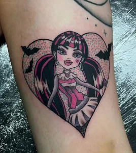 Татуировка в стиле Monster High на бедре с изображением девушки-вампира в сердце