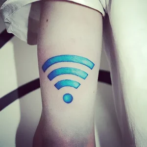 Крупный план татуировки в виде символа Wi-Fi с градиентом от синего к голубому на предплечье человека, выполненная в современном стиле