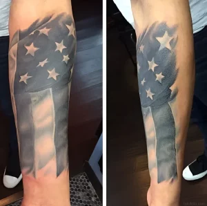 Black and grey realistic American flag tattoo on forearm, waving design with stars and stripes, perfect for National Flag Day inspiration