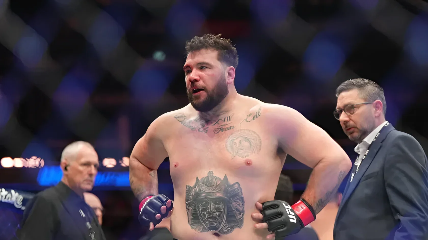 Луи Сазерленд в ринге UFC с видимыми татуировками на груди и животе: портрет, иероглифы и череп