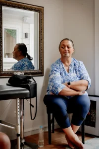 Портрет женщины с татуировкой на подбородке, сидящей в студии тату-мастера в Гисборне, Новая Зеландия