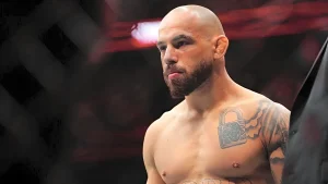 Жан Силва в октагоне UFC с татуировкой замка и четырёхлистного клевера на левой груди и татуировками на плече