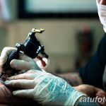 Фото тату процесса нанесения рисунка. Крупный план руки мастера в перчатках и тату-машинки, работающей над кожей клиента.