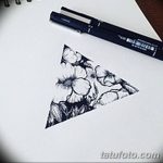 Эскиз татуировки в виде треугольника, внутри которого изображены цветы. Рисунок выполнен в черно-белой гамме и отличается изяществом и женственностью.